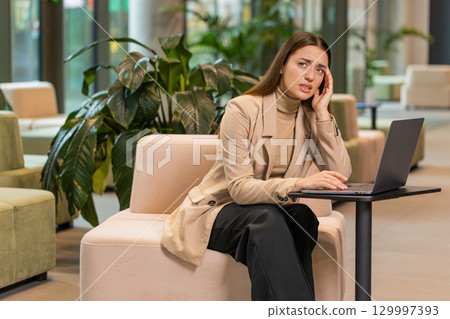 Tired businesswoman freelancer use laptop suffering from headache problem tension migraine stress 129997393