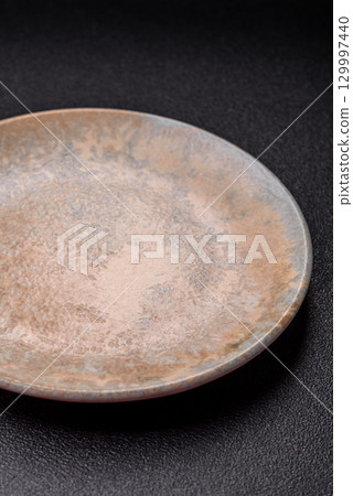 Empty round black plate for food, kitchen utensils on dining table. Empty plate Empty round black plate for food, kitchen utensils on dining table. Empty plate 129997440