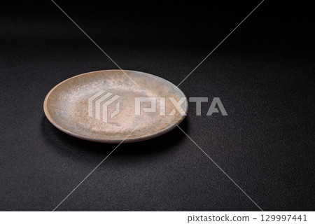 Empty round black plate for food, kitchen utensils on dining table. Empty plate Empty round black plate for food, kitchen utensils on dining table. Empty plate 129997441
