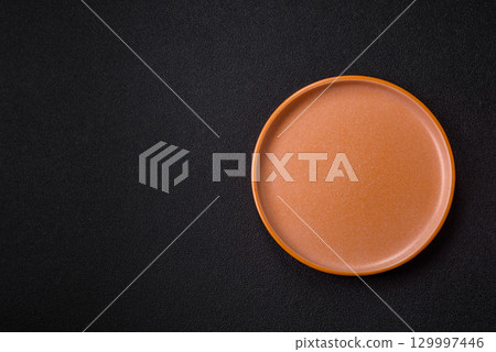 Empty round black plate for food, kitchen utensils on dining table. Empty plate 129997446