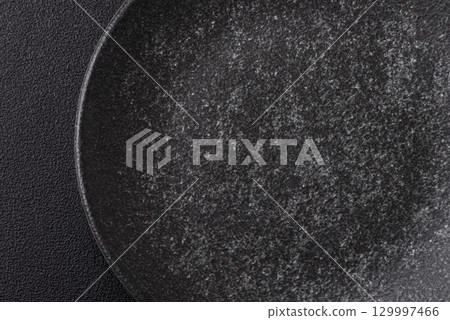 Empty round black plate for food, kitchen utensils on dining table. Empty plate Empty round black plate for food, kitchen utensils on dining table. Empty plate 129997466