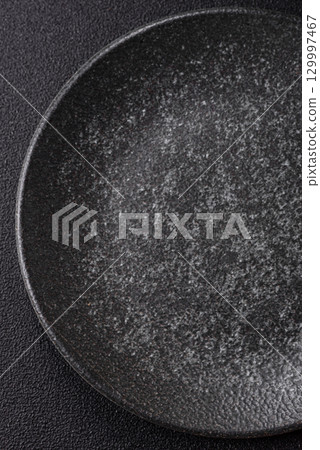 Empty round black plate for food, kitchen utensils on dining table. Empty plate Empty round black plate for food, kitchen utensils on dining table. Empty plate 129997467