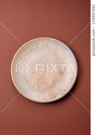 Empty round black plate for food, kitchen utensils on dining table. Empty plate 129997492