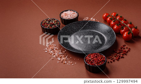 Empty round black plate for food, kitchen utensils on dining table. Empty plate 129997494