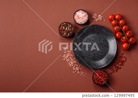 Empty round black plate for food, kitchen utensils on dining table. Empty plate Empty round black plate for food, kitchen utensils on dining table. Empty plate 129997495