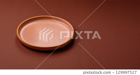 Empty round black plate for food, kitchen utensils on dining table. Empty plate 129997527