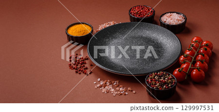 Empty round black plate for food, kitchen utensils on dining table. Empty plate Empty round black plate for food, kitchen utensils on dining table. Empty plate 129997531