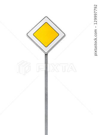A yellow priority road traffic sign mounted on a metal post, isolated on white 129997792