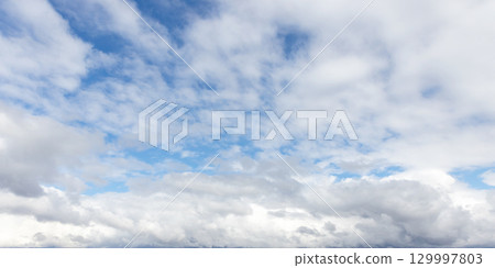 A serene view of a bright sky featuring fluffy white clouds A serene view of a bright sky featuring fluffy white clouds 129997803