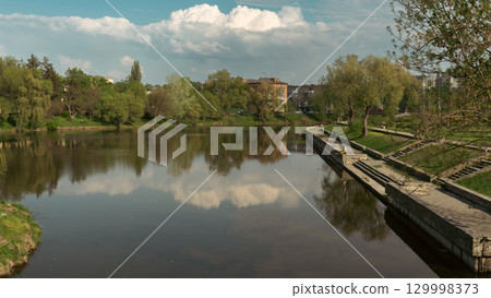 Calm River with Trees and Reflections under Blue Sky Calm River with Trees and Reflections under Blue Sky 129998373