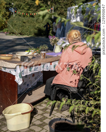 a retired woman sells plants at a city fair 129998647