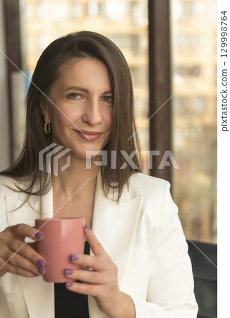 Portrait of mature business woman with arms crossed looking at camera. onfident Portrait of mature business woman with arms crossed looking at camera. onfident 129998764