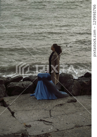 young girl on the seashore around the rocks young girl on the seashore around the rocks 129998766