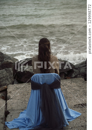 young girl on the seashore around the rocks young girl on the seashore around the rocks 129998772