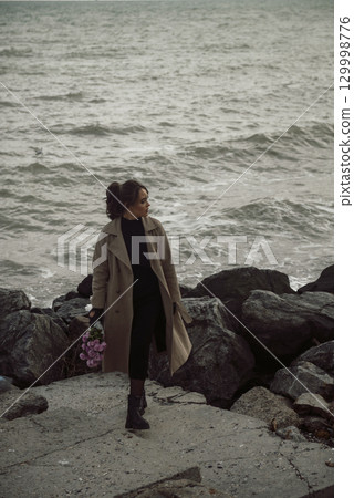 young girl on the seashore around the rocks young girl on the seashore around the rocks 129998776