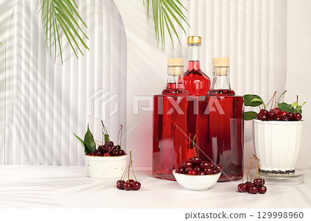 Homemade hard cherry cider in bottles on elegant background, still life with alcoholic drinks and fresh cherries, home winemaking concept, minimalist banner for bar, advertising banner for cafe 129998960