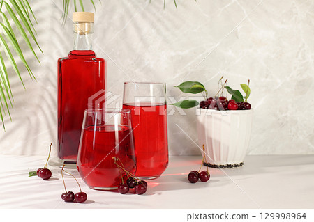 Homemade strong cherry cider in bottles and glasses on elegant background, still life with alcoholic drinks and fresh cherries, home winemaking concept, minimalist banner for bar, Homemade strong cherry cider in bottles and glasses on elegant background, still life with alcoholic drinks and fresh cherries, home winemaking concept, minimalist banner for bar, 129998964