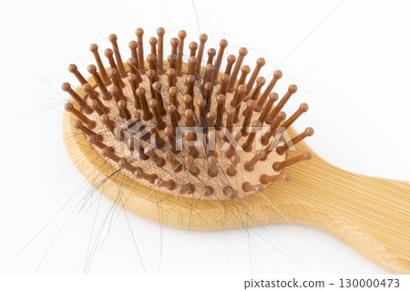 Close-up of a bamboo hairbrush with hair Close-up of a bamboo hairbrush with hair 130000473