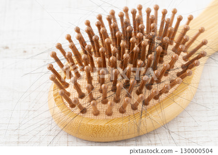 Close-up of a bamboo hairbrush with hair Close-up of a bamboo hairbrush with hair 130000504