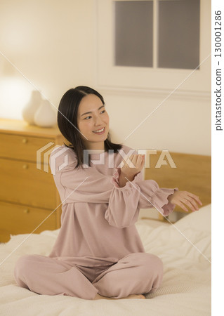 一個女人坐在床上 一個女人坐在床上 130001286