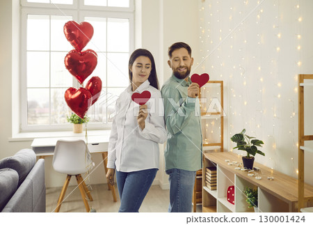 Happy young man and woman in love are celebrating Saint Valentine's Day at home Happy young man and woman in love are celebrating Saint Valentine's Day at home 130001424