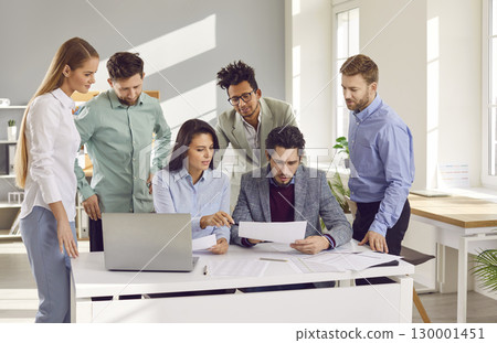 Group of busy confident business people working together in office 130001451