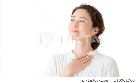 A woman squints her eyes with her hand on her chest, expressing satisfaction and happiness 130001766