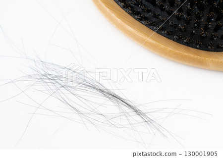Close-up of a boar bristle hairbrush and loose hair on a white background 130001905