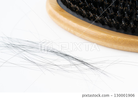 Close-up of a boar bristle hairbrush and loose hair on a white background 130001906