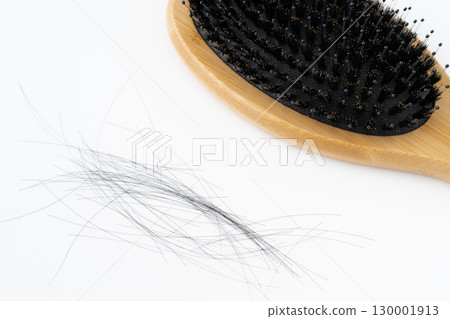Close-up of a boar bristle hairbrush and loose hair on a white background Close-up of a boar bristle hairbrush and loose hair on a white background 130001913