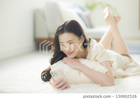 一個操作智能手機的年輕女子 130002526