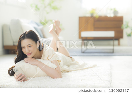 一個操作智能手機的年輕女子 一個操作智能手機的年輕女子 130002527