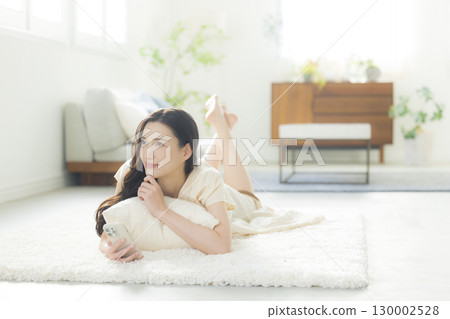 一個操作智能手機的年輕女子 一個操作智能手機的年輕女子 130002528