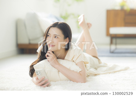 一個操作智能手機的年輕女子 130002529