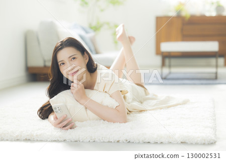 A young woman operating a smartphone A young woman operating a smartphone 130002531