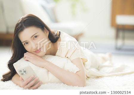A young woman operating a smartphone A young woman operating a smartphone 130002534