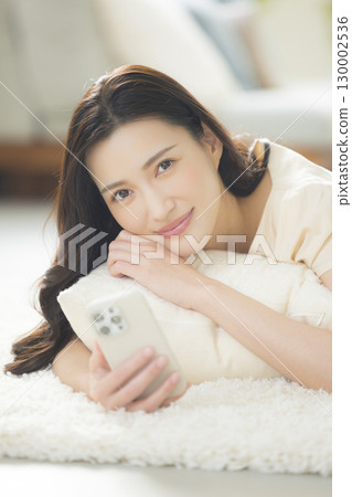 一個操作智能手機的年輕女子 130002536