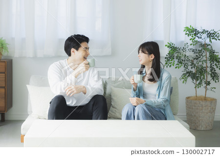 Male and female relaxing on the sofa 130002717
