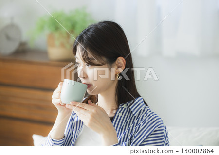 年輕女子在房間裡喝咖啡 130002864
