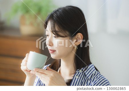 年輕女子在房間裡喝咖啡 130002865