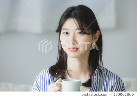 年輕女子在房間裡喝咖啡 130002869