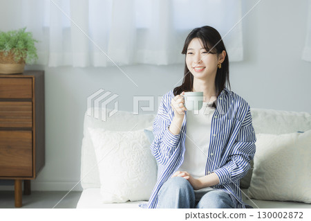 Young woman drinking coffee in the room Young woman drinking coffee in the room 130002872