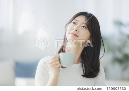 Young woman drinking coffee in the room Young woman drinking coffee in the room 130002880