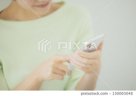 Woman operating a smartphone Woman operating a smartphone 130003048