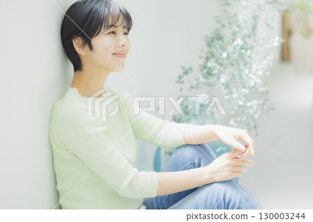 Young woman leaning against a wall Young woman leaning against a wall 130003244