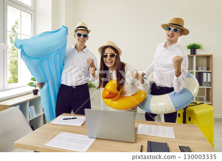 Joyful team of office workers ready to go on summer vacation having fun in office. 130003335