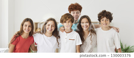 Group teen portrait of young excited people together standing smiling in team, candid funny students Group teen portrait of young excited people together standing smiling in team, candid funny students 130003376