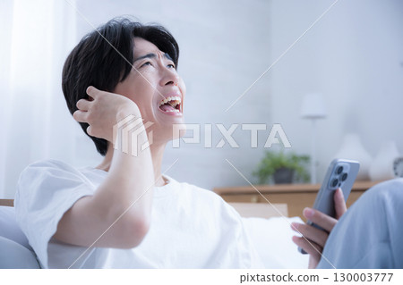 A person who is surprised and embarrassed by holding a smartphone 130003777