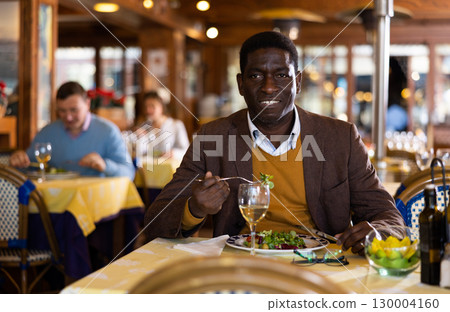 African-american man eating in restaurant African-american man eating in restaurant 130004160