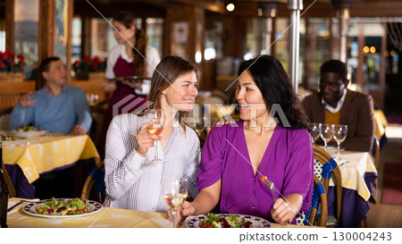 Friendly meeting of two women over dinner in restaurant 130004243